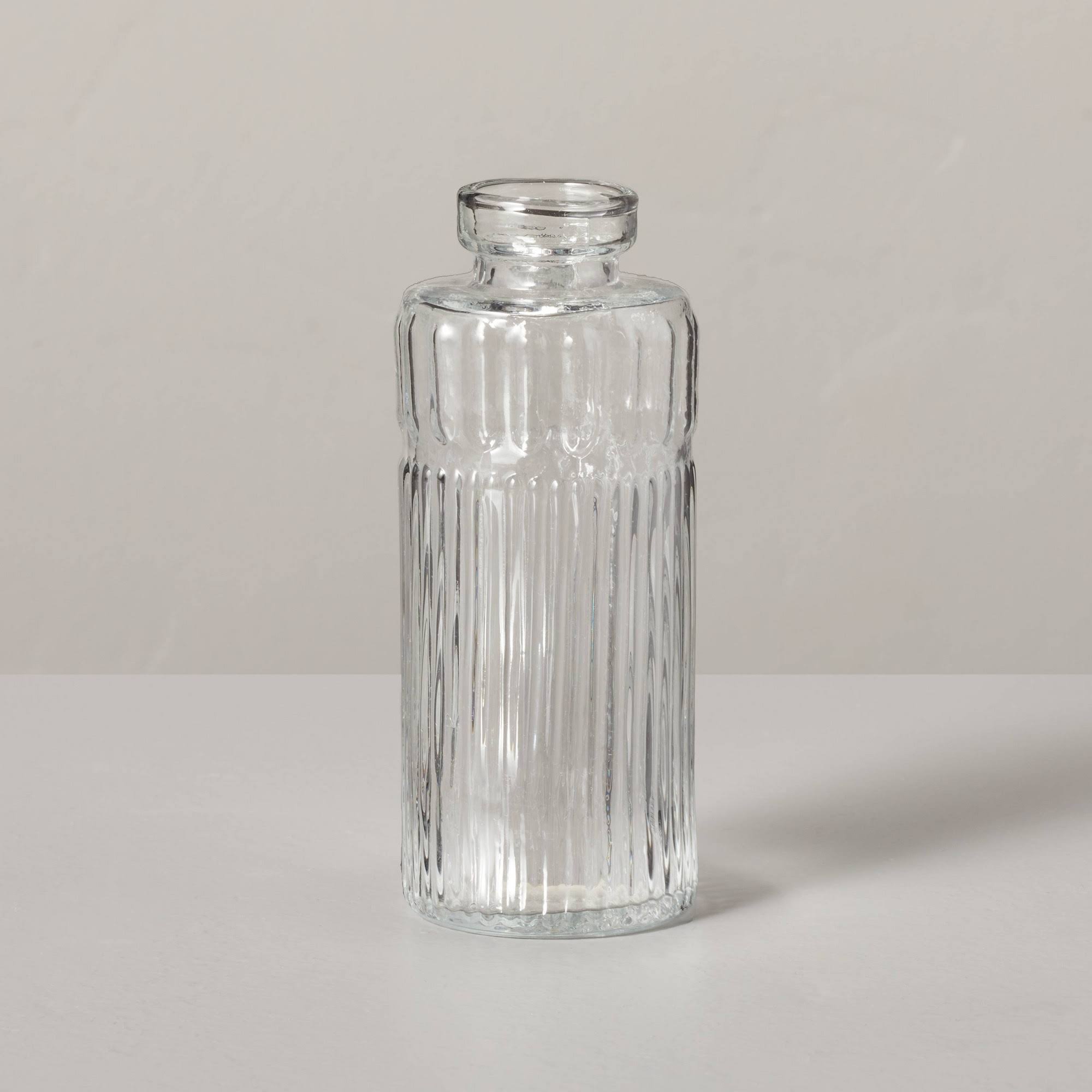 6a63f32d223a10255d987971a0b5e77a90d40f82b82195fa1e936711292adcb3.jpg Medium Ribbed Clear Glass Bud Vase - Hearth & Hand with Magnolia - Image 1