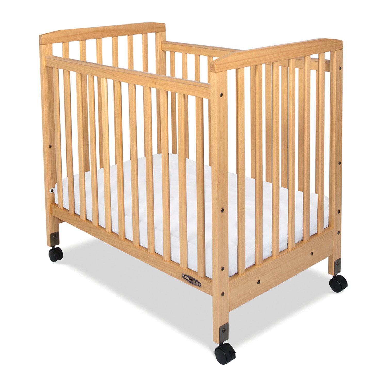 a5e77cd8b9562de069e1e7da265f325a47ed0f384a2d938828ff033e271e2d33.jpg Child Craft Bristol Compact Portable Crib with 3″ Mattress. Durable Wood Frame. Quiet Casters. Natural - Image 1